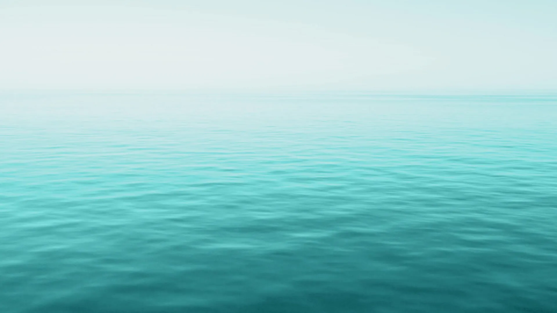 Calm turquoise water stretching to a hazy horizon